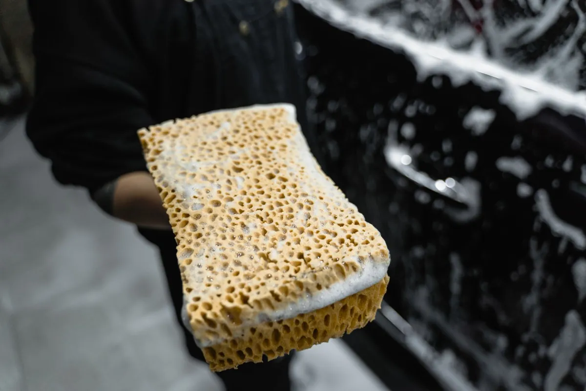 A soapy wash mitt beside a car during a hand wash